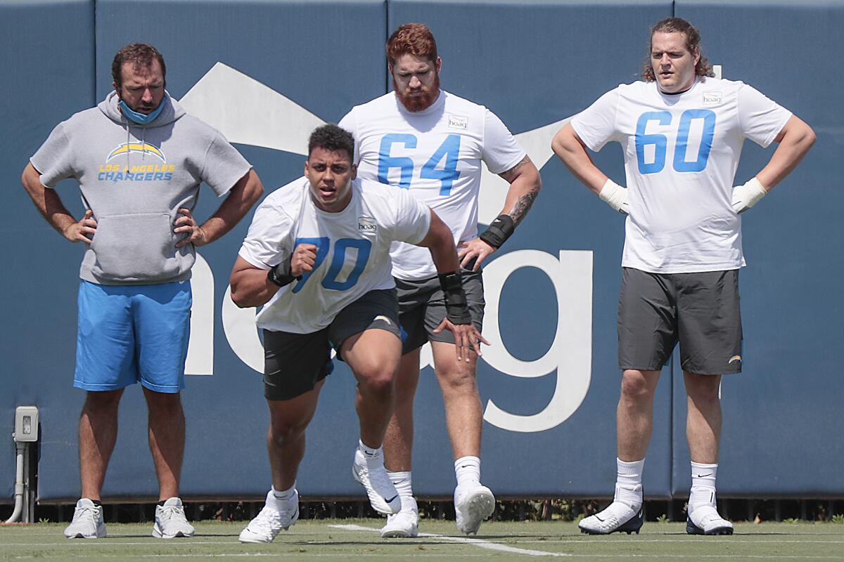 Tackle Rashawn Slater (70) leads an offensive lineman drill.