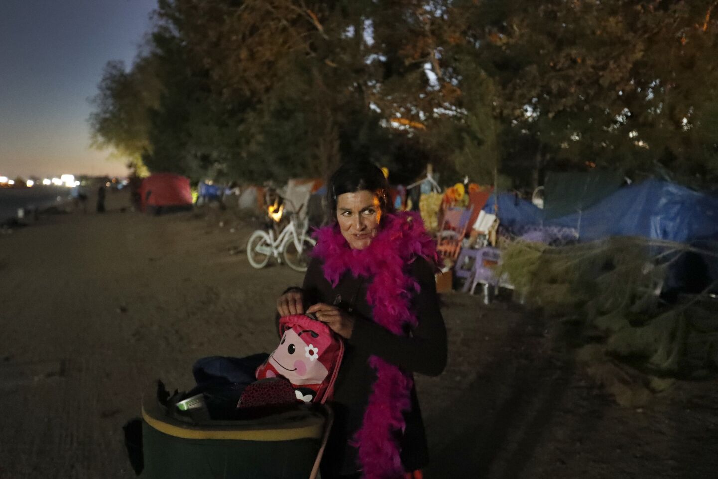 Linda O'Reilly, who has been homeless for five years, moves her belongings out of the large encampment along the Santa Ana River trail.
