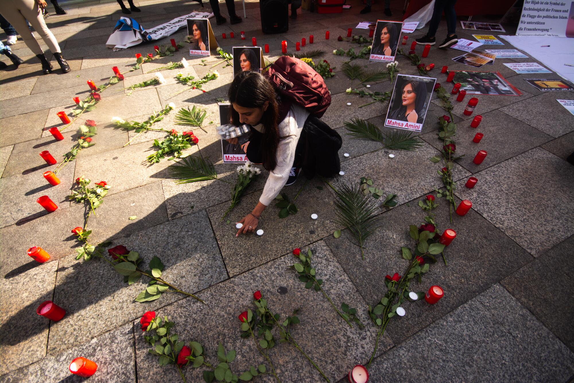 Flowers and candles are arranged in the shape of a heart in front of Dom Cathedral in Cologne, Germany