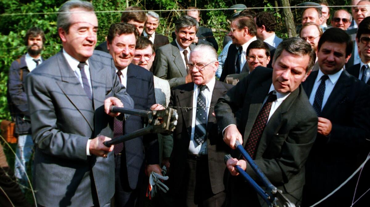 Alois Mock, left, then Austria's foreign minister, and Hungarian Foreign Minister Gyula Horn cut though the barbed wire representing the Iron Curtain in 1989.