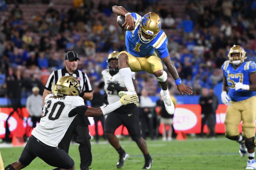 Pasadena, California November 13, 2021: UCLA quarterback Dorian Thompson-Robinson leaps.