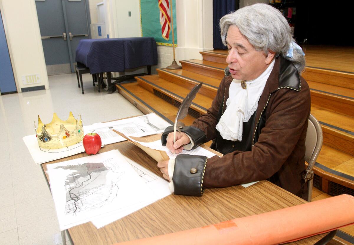 Thomas Jefferson, played by Peter M. Small of Costa Mesa, writes the Declaration of Independence as he speaks to fifth-grade students at Jefferson Elementary School, in Glendale.