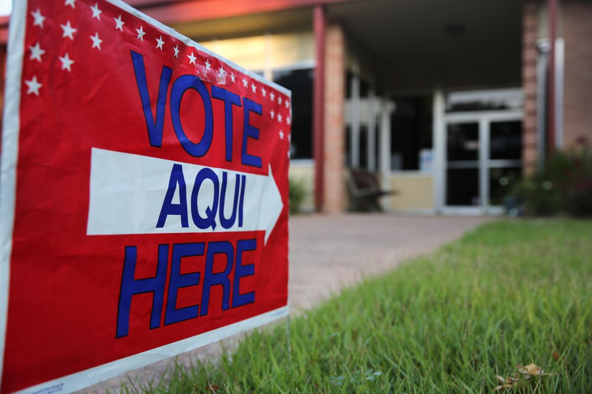 A bilingual sign with the words "Vote Aqui Here" outside a polling center in Austin, Texas.