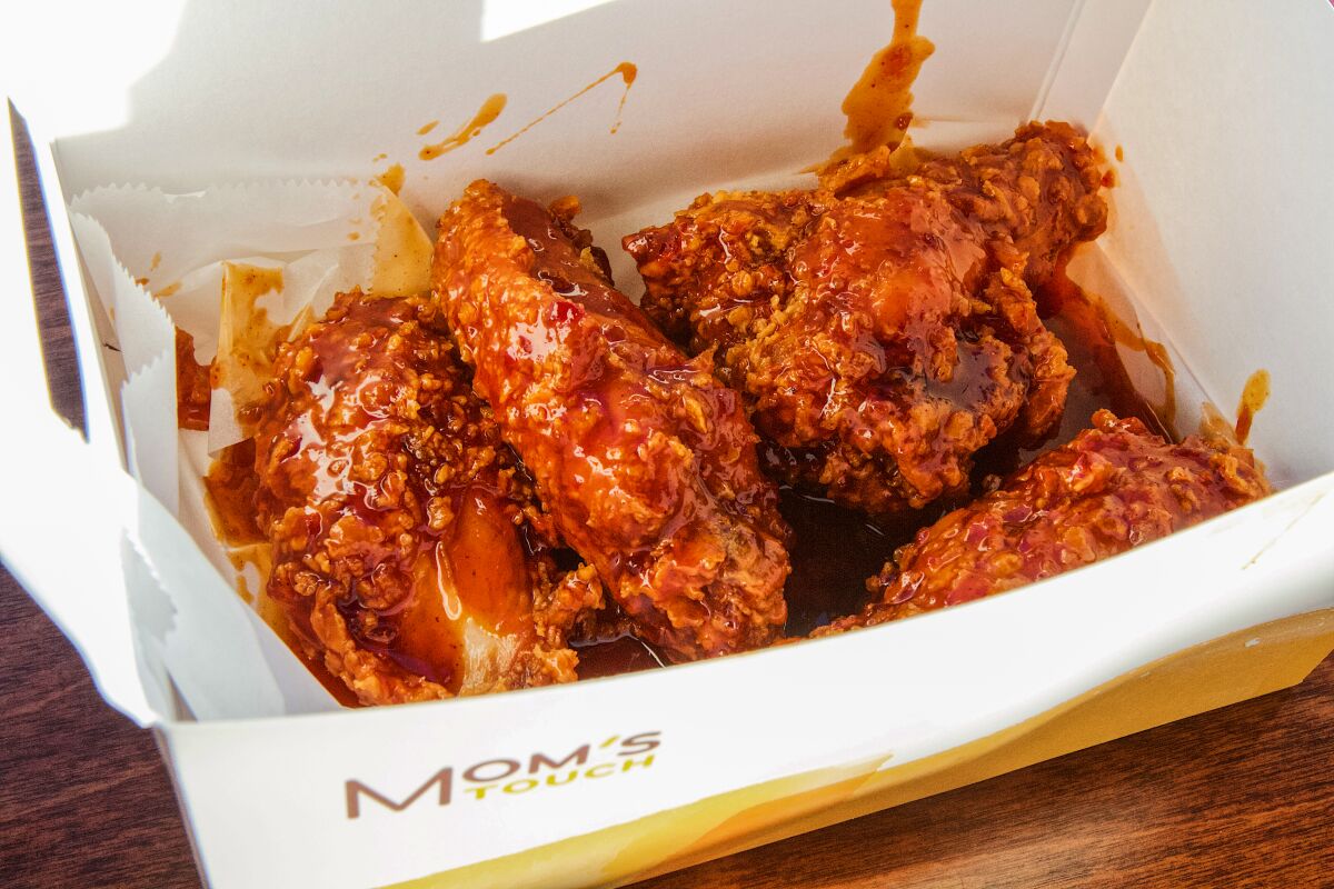A box full of saucy chicken wings from Mom’s Touch.