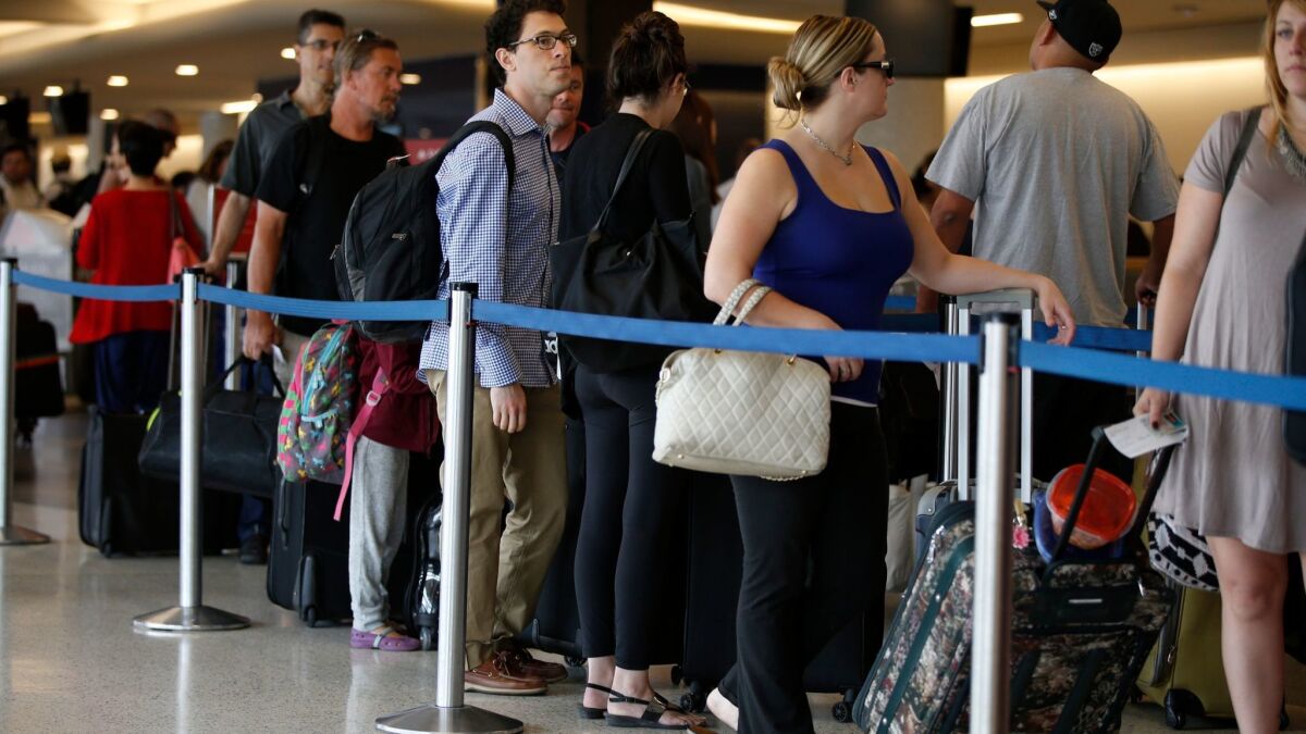 Travelers in Terminal 5 of Los Angeles International Airport wait in long lines at the Delta Air Lines counter during the Labor Day holiday weekend in 2015. An estimated 888,000 travelers are expected to fly through the airport this holiday weekend.