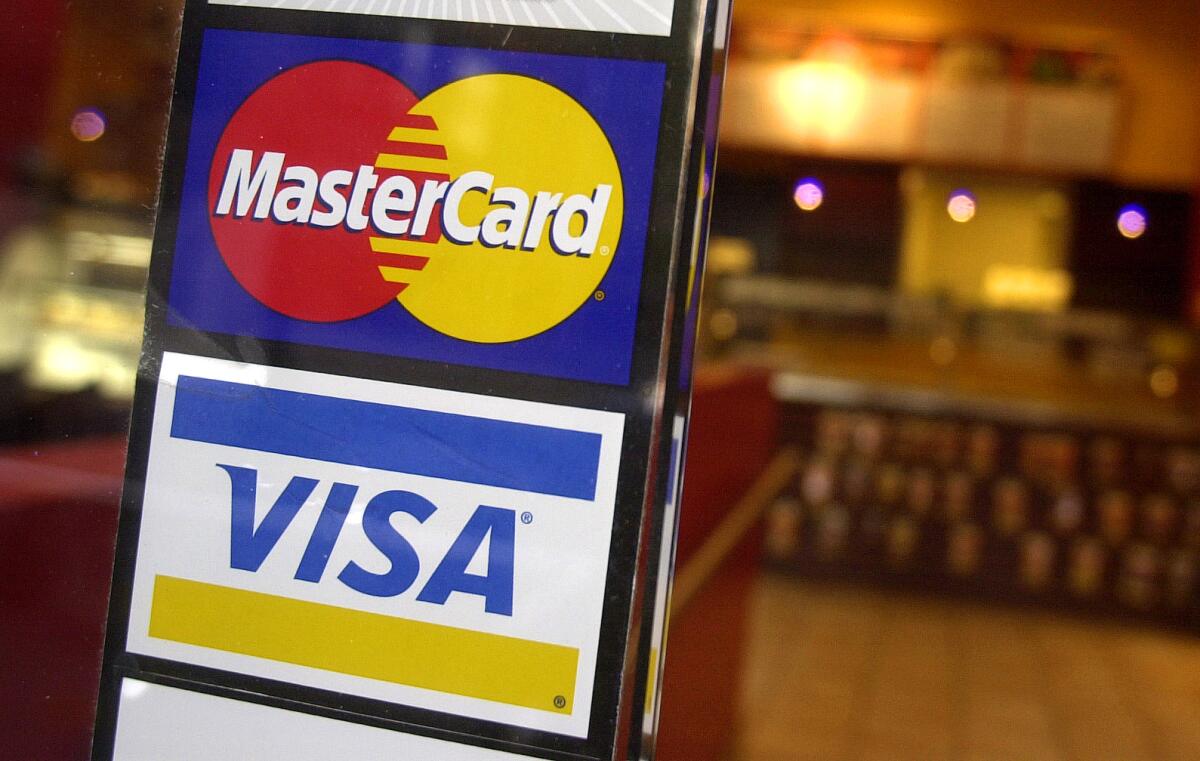Logos for MasterCard and Visa credit cards at the entrance of a coffee shop