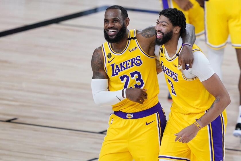 Los Angeles Lakers' LeBron James (23) and Anthony Davis (3) celebrate after defeating the Denver Nuggets 124-121 during an NBA basketball game Monday, Aug. 10, 2020, in Lake Buena Vista, Fla. (AP Photo/Ashley Landis, Pool)
