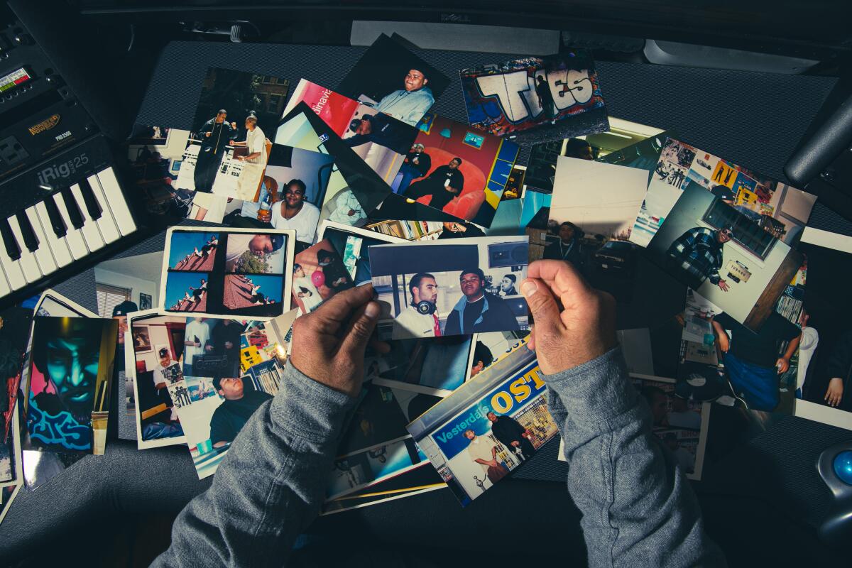 Two hands holding a photo above several more.