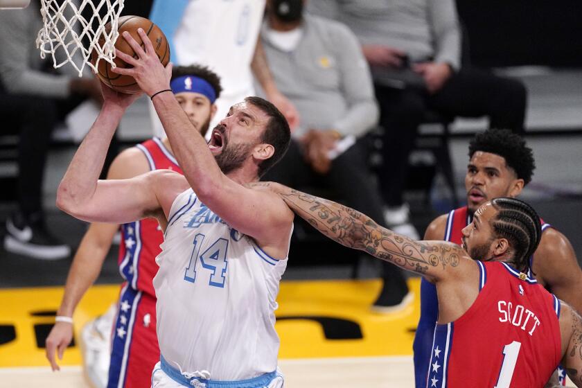 Los Angeles Lakers center Marc Gasol, left, is fouled by Philadelphia 76ers forward Mike Scott as he shoots during the first half of an NBA basketball game Thursday, March 25, 2021, in Los Angeles. (AP Photo/Mark J. Terrill)