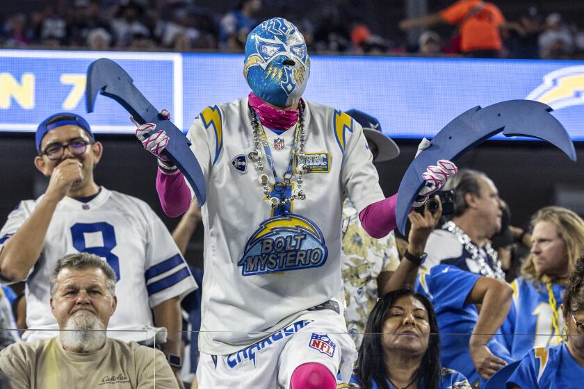 A Chargers fan in lucha libre gear cheers during a "Monday Night Football" game against the Dallas Cowboys at SoFi Stadium.