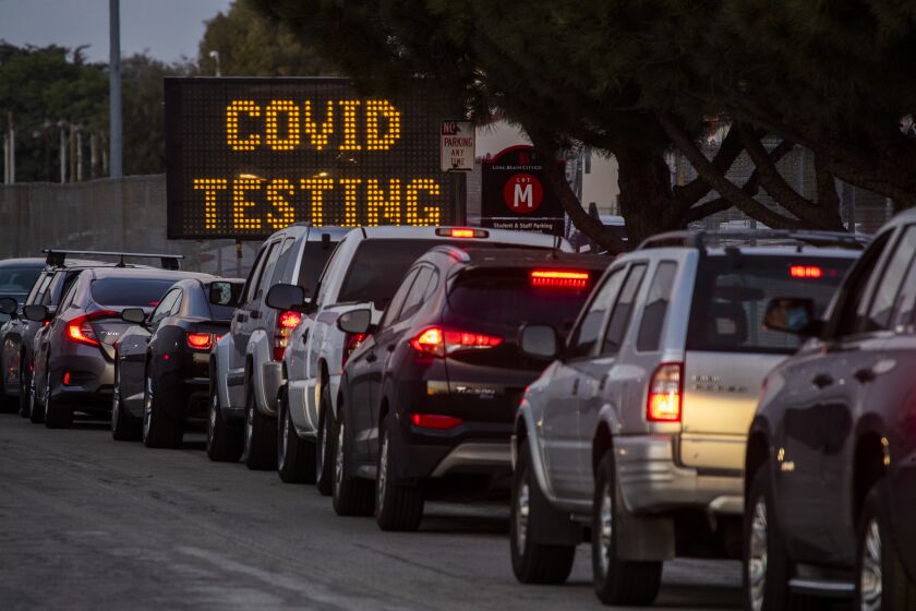 Motorists line up to take COVID-19 tests at  Long Beach City College-Veterans Memorial Stadium.