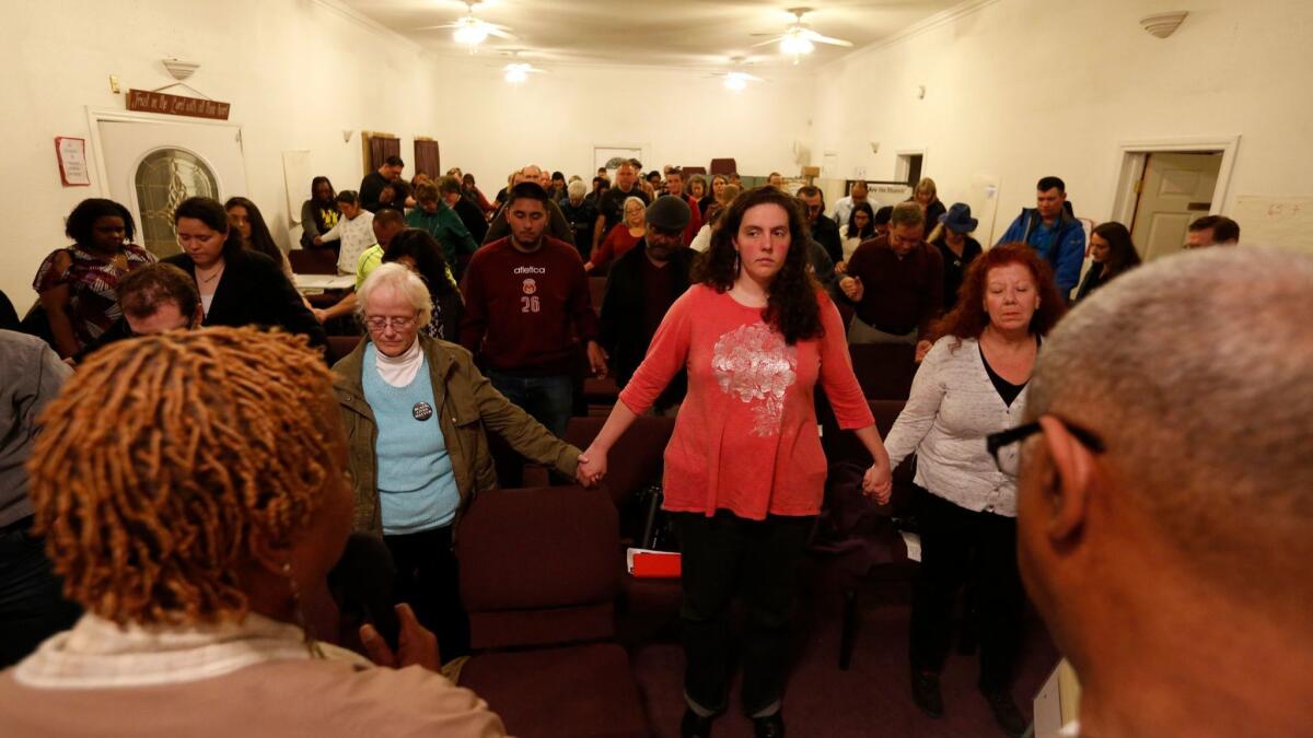 Participants join hands and sing a hymn to close a training session at Rising Star Missionary Baptist Church in Fresno for religious leaders and community members who wish to support immigrants facing deportation. (Genaro Molina / Los Angeles Times)