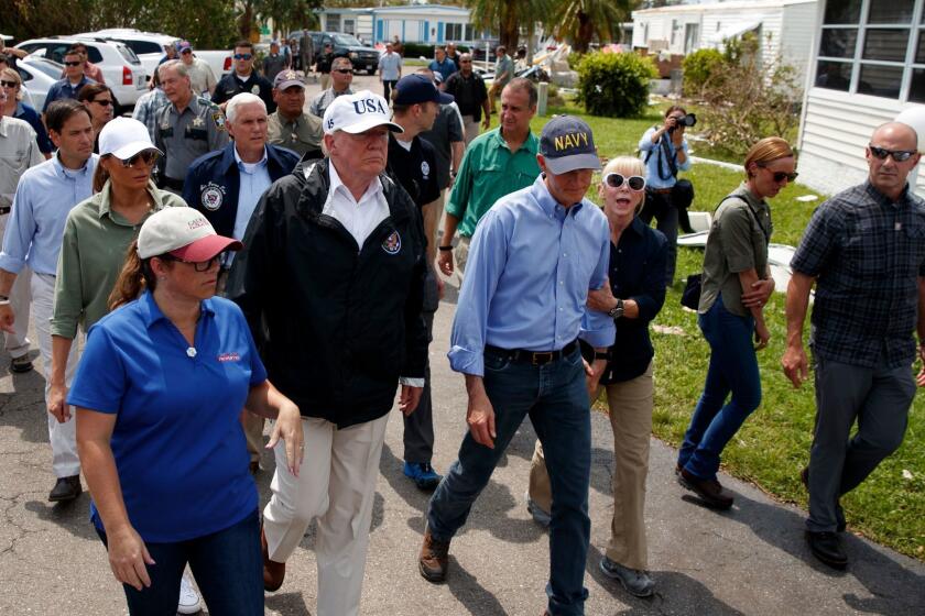 President Donald Trump, first lady Melania Trump, second row left, and Vice President Mike Pence, tour Naples Estates, a neighborhood impacted by Hurricane Irma, Thursday, Sept. 14, 2017, in Naples, Fla. (AP Photo/Evan Vucci)