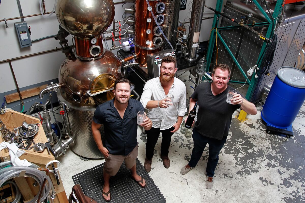 Distillers (from left) Whit Rigali , Blake Carver, and Sam Chereskin toast their Misadventure Vodka on Friday at California Spirits Company in San Marcos, California.