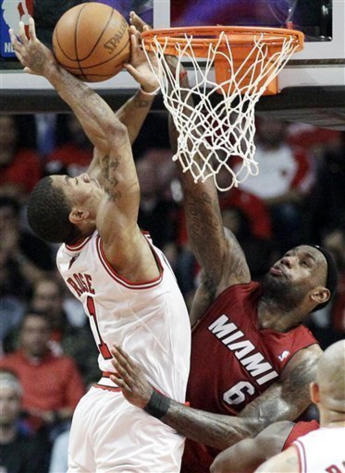 The Miami Heat's LeBron James (6) is tied up in the paint by the