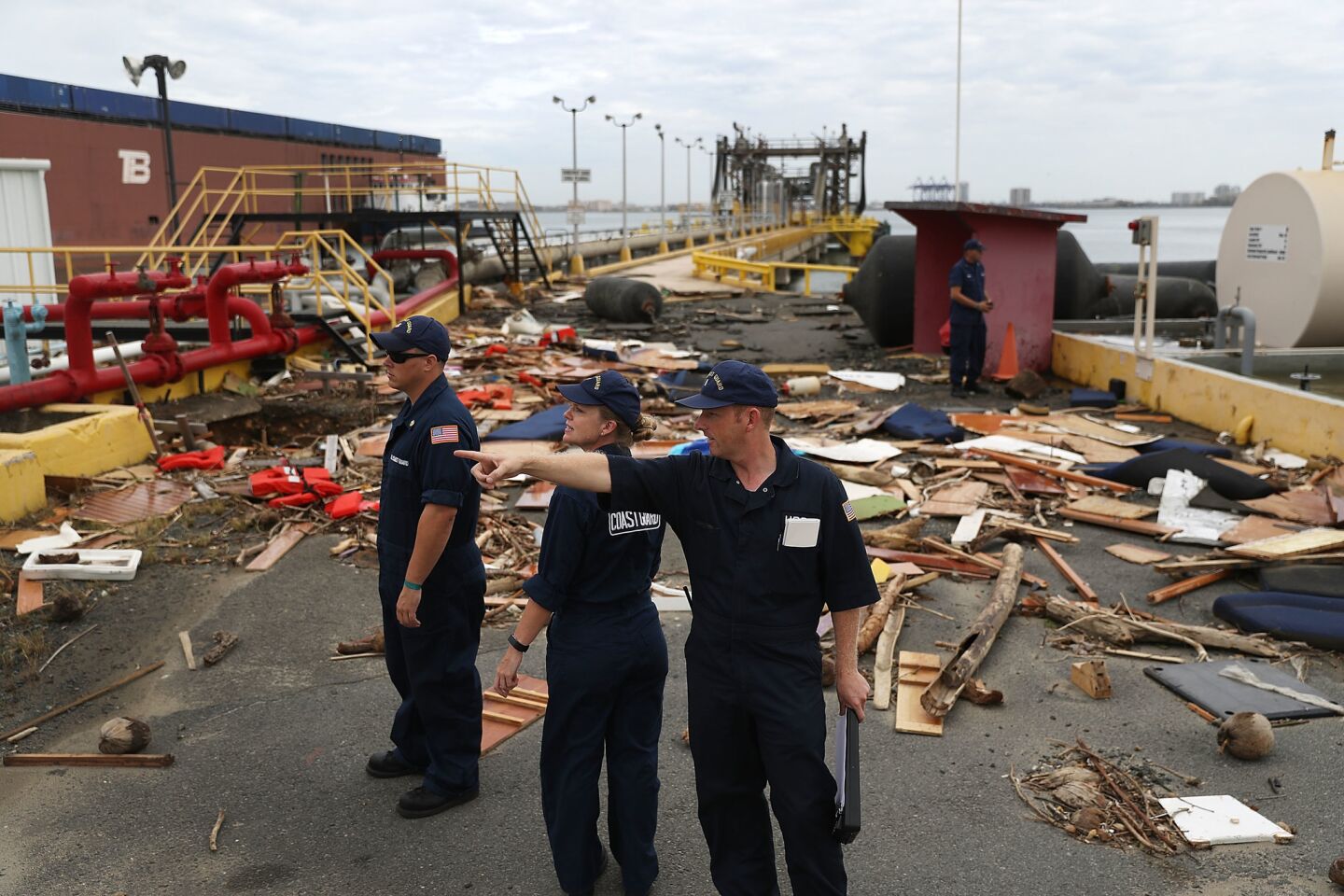 U.S. Coast Guard personnel survey the damage to an oil dock after Hurricane Maria passed through the area in San Juan, Puerto Rico.