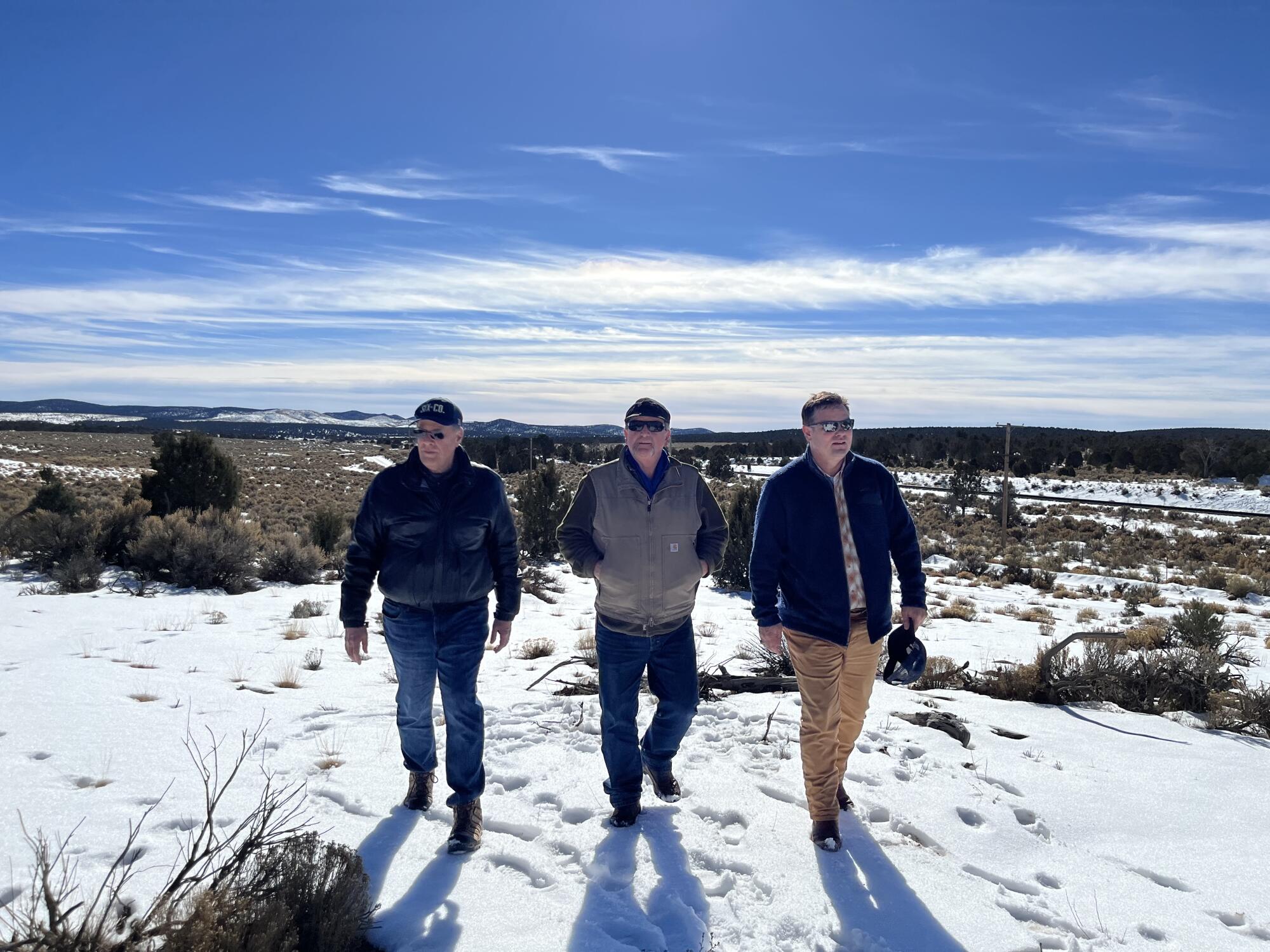 Three men walk in the proposed biofuel project site surrounded by 1.3 million acres of pinyon-juniper forest
