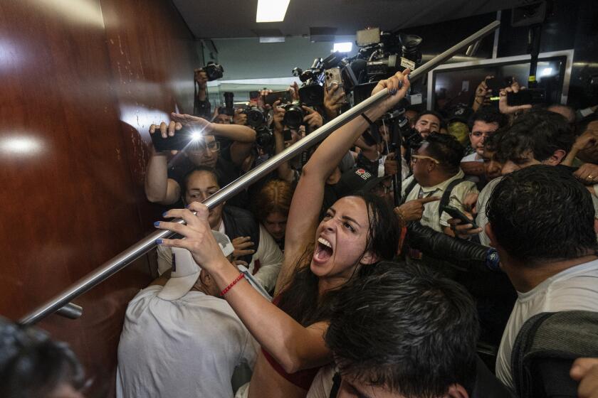 Protesters attempt to break into a room in the Senate as lawmakers weigh the government's proposed judicial reform, which would make judges stand for election, in Mexico City, Tuesday, Sept. 10, 2024. (AP Photo/Felix Marquez)