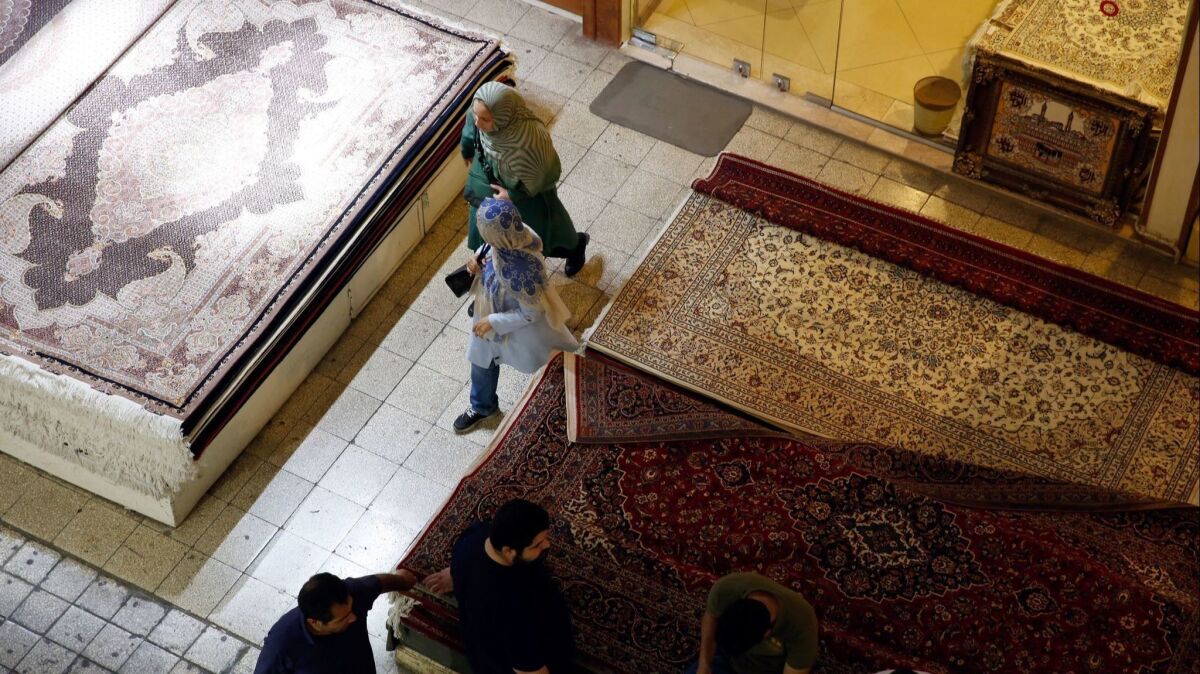 Iranians walk through a carpet market inside Tehran's old bazaar.