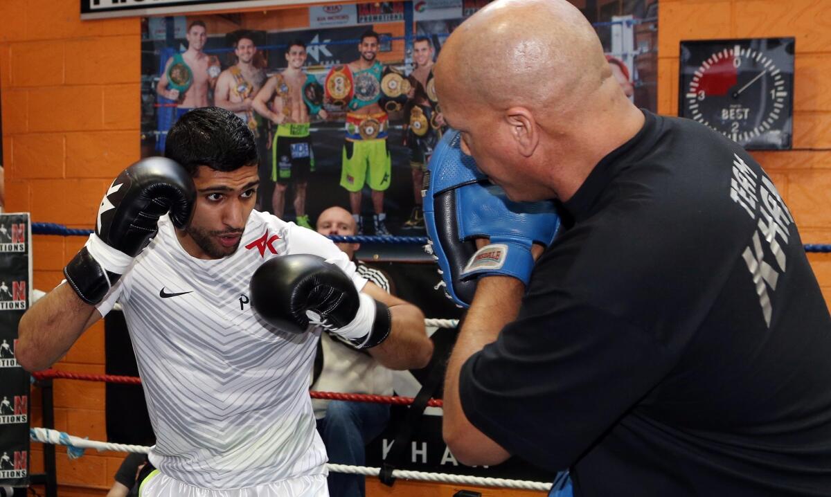 Amir Khan works out with his trainer, Virgil Hunter, in Bolton, England, on March 24.