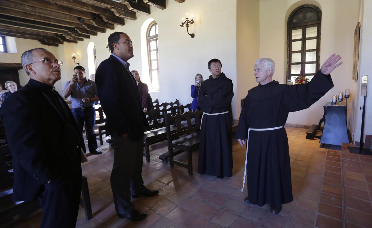 Father David Garcia, left, tours Mission Espada in San Antonio.