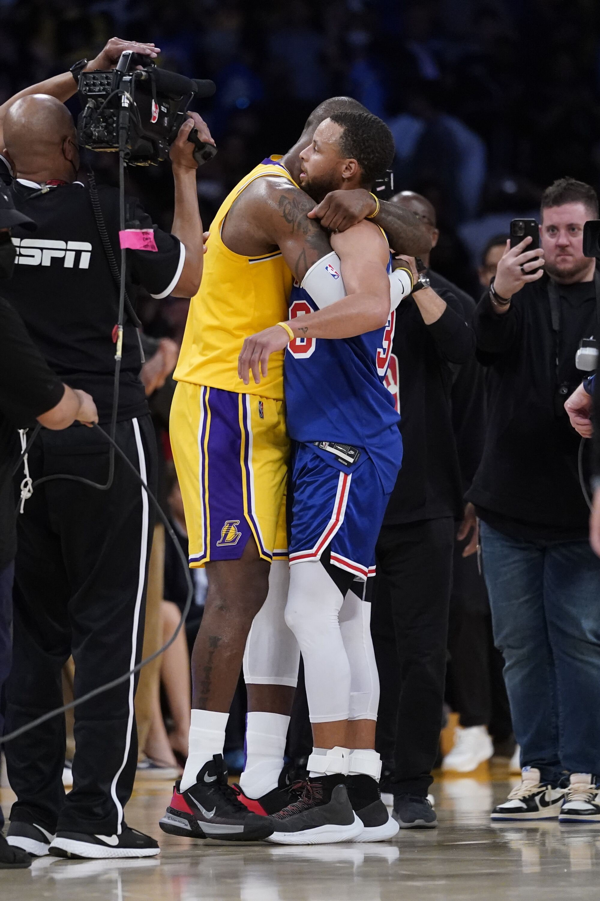 Lakers forward LeBron James and Warriors guard Stephen Curry embrace after the game.