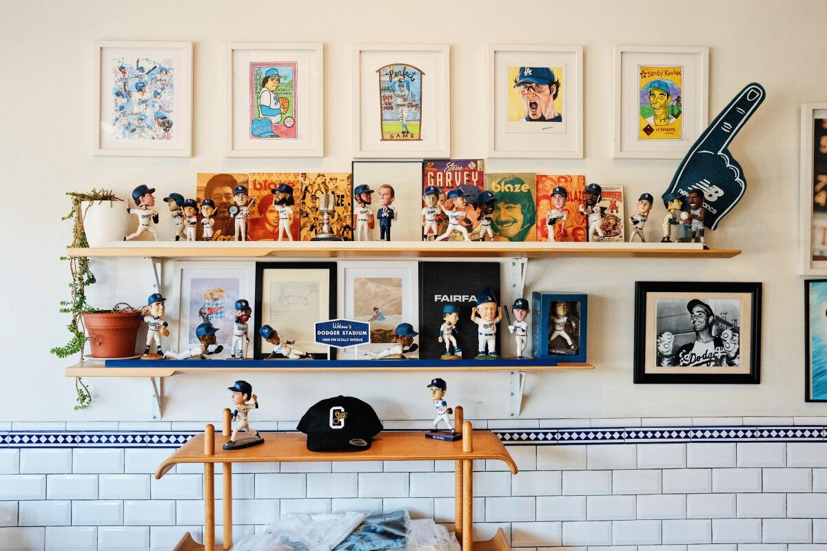 Shelves of collectible Dodgers memorabilia such as bobble heads, shirts and art at Cofax Coffee on Fairfax.