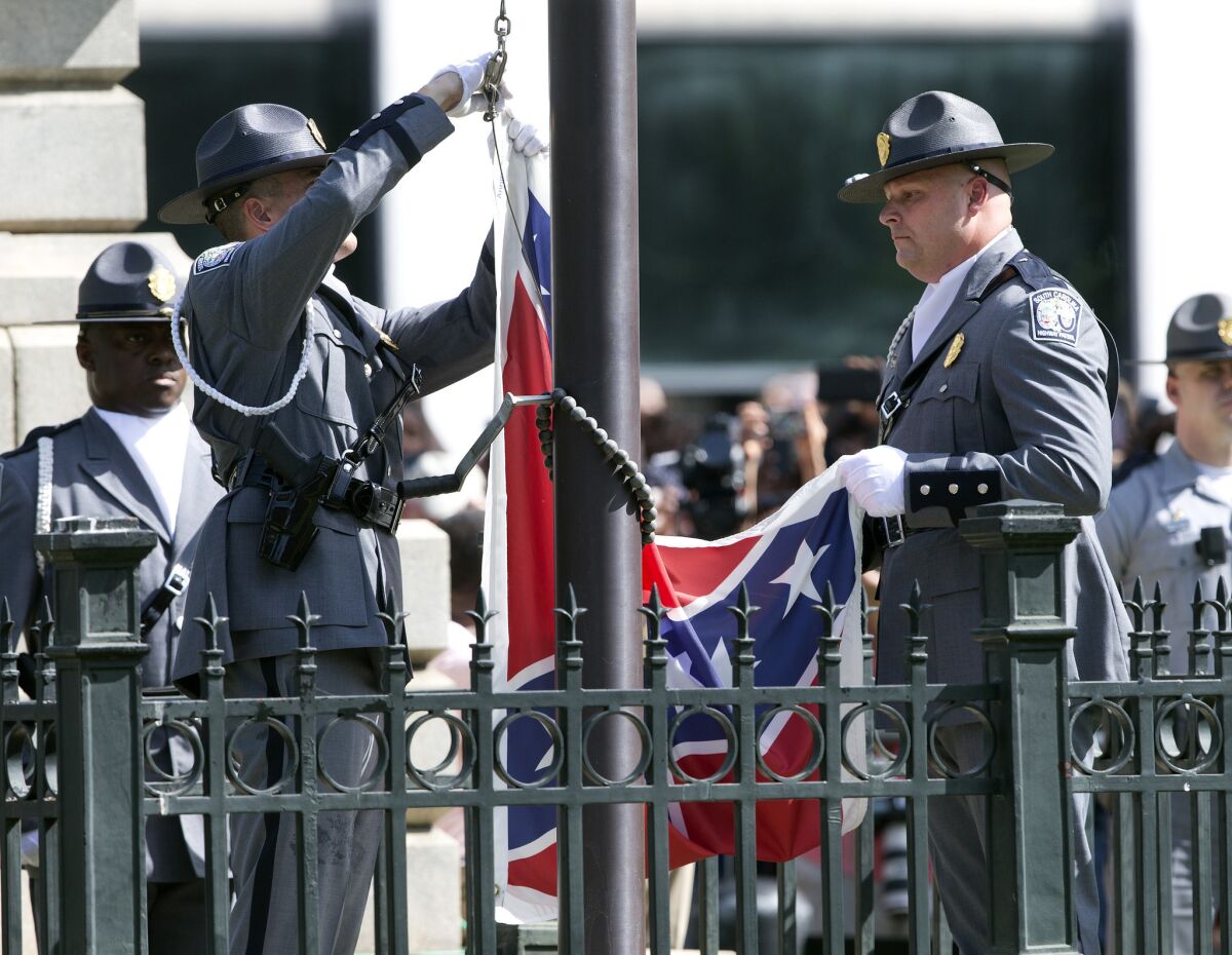 An honor guard from the South Carolina Highway Patrol lowers the Confederate battle flag as it is removed from the Capitol grounds on July 10 in Columbia, S.C.