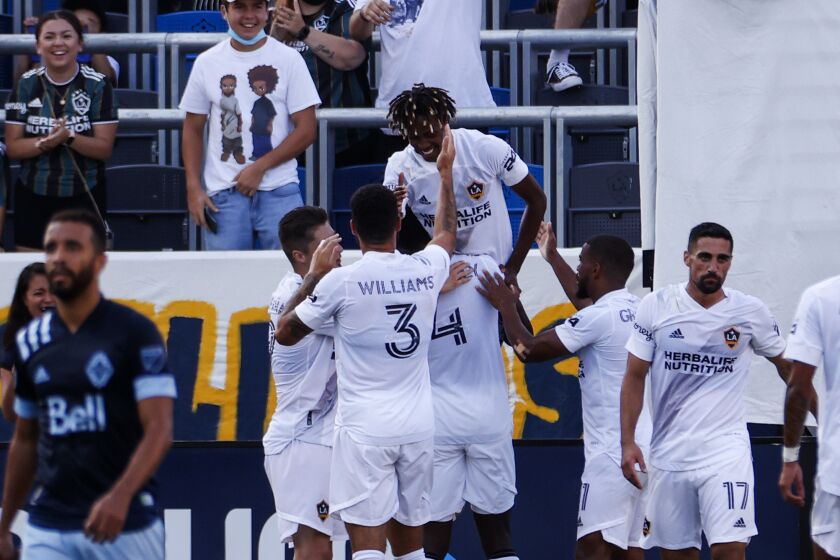 LA Galaxy midfielder Kevin Cabral, center, celebrates his goal with teammates in the first half of an MLS soccer match against the Vancouver Whitecaps in Carson, Calif., Sunday, Aug. 8, 2021. (AP Photo/Ringo H.W. Chiu)