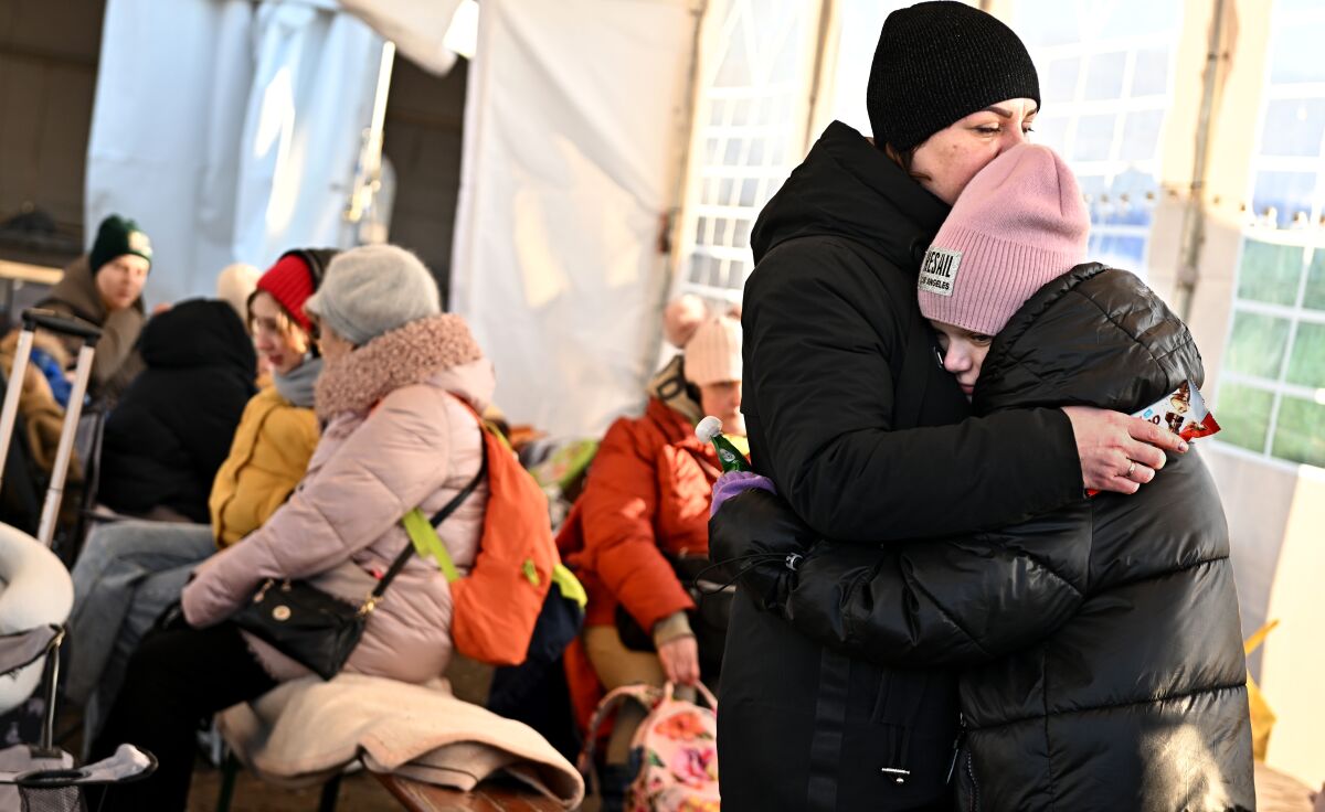 Ukrainian refugees hug inside a temporary shelter at the border in Medyka, Poland.