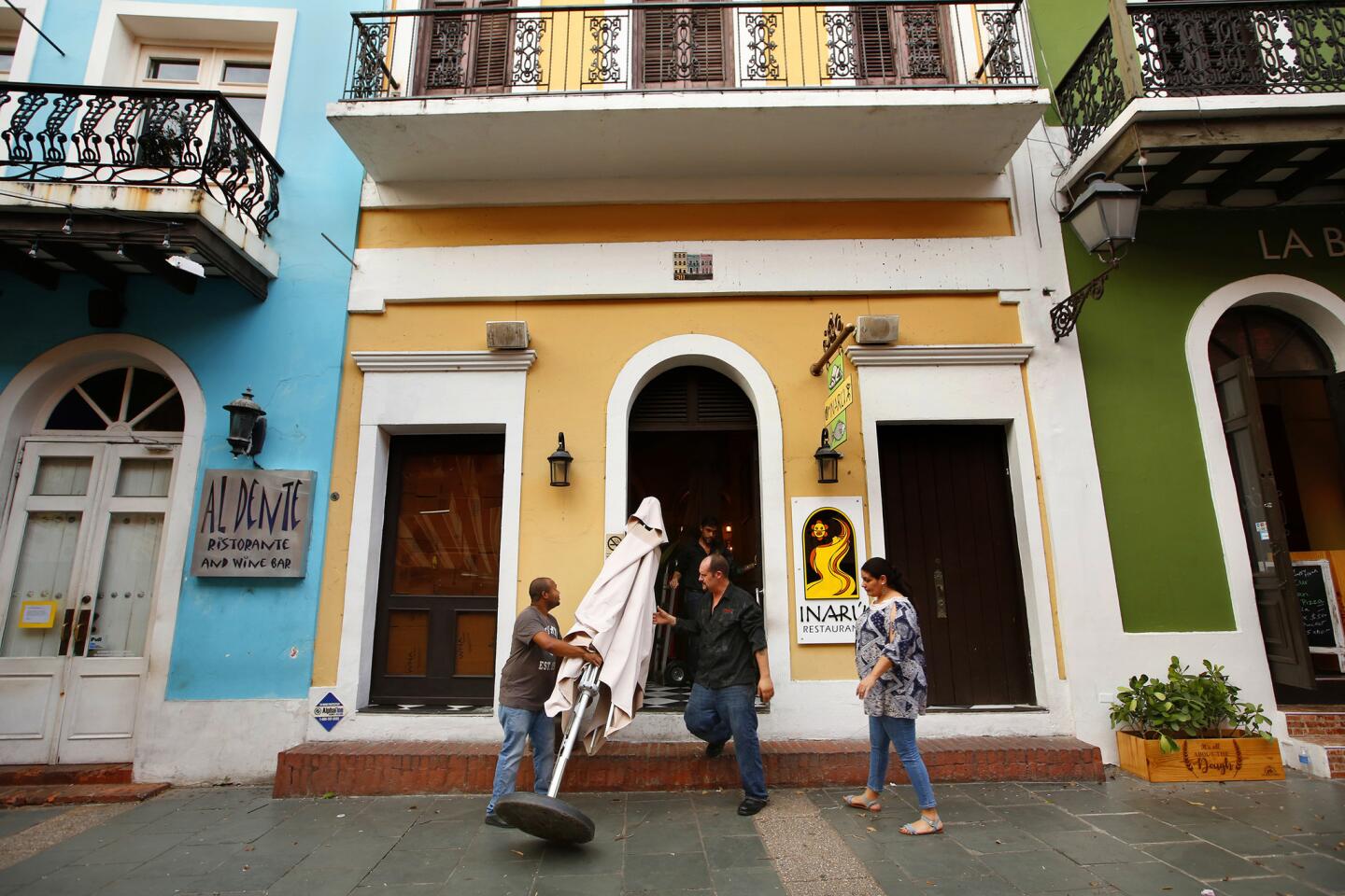 Workers at the Inaru restaurant in Old San Juan take in umbrellas and close early in anticipation of Hurricane Maria.