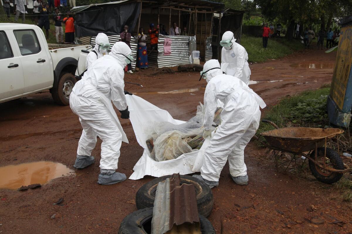 Liberian nurses remove a victim of Ebola from a street in Virginia on the outskirts of the capital Monrovia, Liberia.