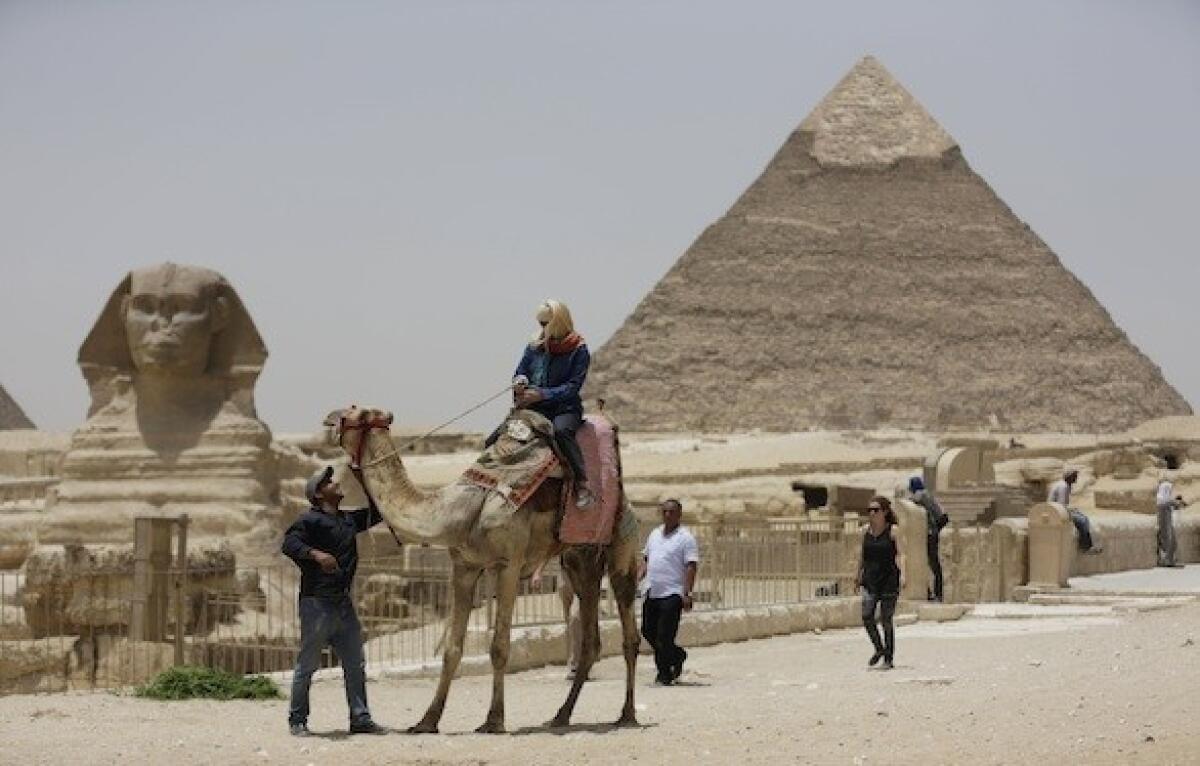 A tourist takes a camel ride at the pyramids in Giza, Egypt. The U.S. Embassy in Cairo recently warned Americans about their safety in the area.