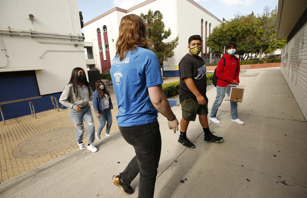 Math and computer science teacher Kelly Flood walks her freshman students around the James A. Garfield High School campus