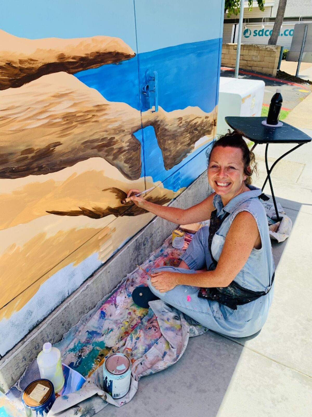Artist Kristel Boe works on one of her creations in front of Cabrillo Elementary School.