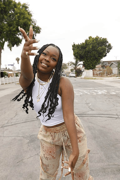 An animated GIF of a woman with braids, wearing a white sleeveless shirt and joggers