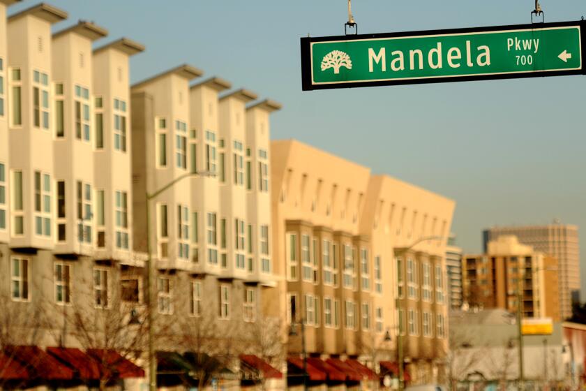 A sign for Mandela Parkway hangs in front of the Mandela Gateway apartment complex, left, in Oakland, Calif., on Thursday, Dec. 12, 2013. The name of former South African president Nelson Mandela can be seen on hundreds of streets, buildings and other community facilities, from Africa to Asia and Europe to the Americas, highlighting the global influence of 'Madiba.' (Photo/Noah Berger)