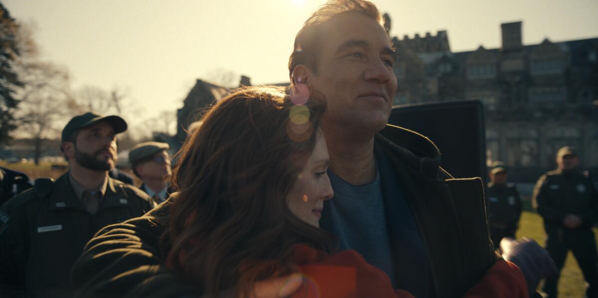 A woman and a man embrace at an outdoor event