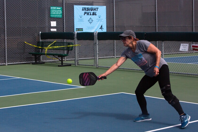 A woman plays pickleball