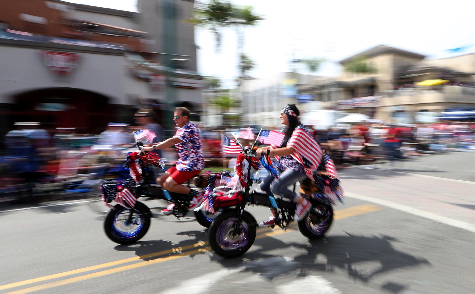 Cyclists ride flag-decked bicycles on Main Street