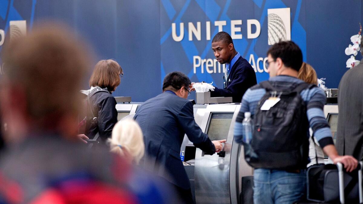 Passengers check in for flights with United Airlines at Chicago's O'Hare Airport. A new ruling by the Department of Justice clarifies that gate agents are covered under a federal statute that protects TSA agents and airport security officers from assaults.