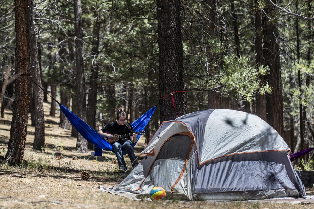 Camping with his family at Heart Bar Campground, Alex Ainsworth,15, plucks a guitar while lounging in a hammock. 