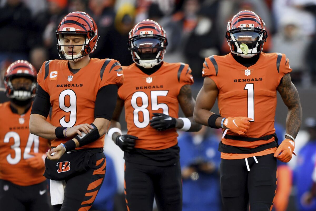 FILE - Cincinnati Bengals quarterback Joe Burrow (9), wide receiver Tee Higgins (85) and Cincinnati Bengals wide receiver Ja'Marr Chase (1) run onto the field during an NFL football game against the Kansas City Chiefs, Sunday, Dec. 4, 2022, in Cincinnati. The Bengals’ Burrow, Chase and Higgins have been a winning trio this year and Cincinnati fans should enjoy them while they can. Their days together could be numbered. Burrow will demand a huge contract next summer with Higgins and Chase knocking on the door soon after. (AP Photo/Emilee Chinn, File)