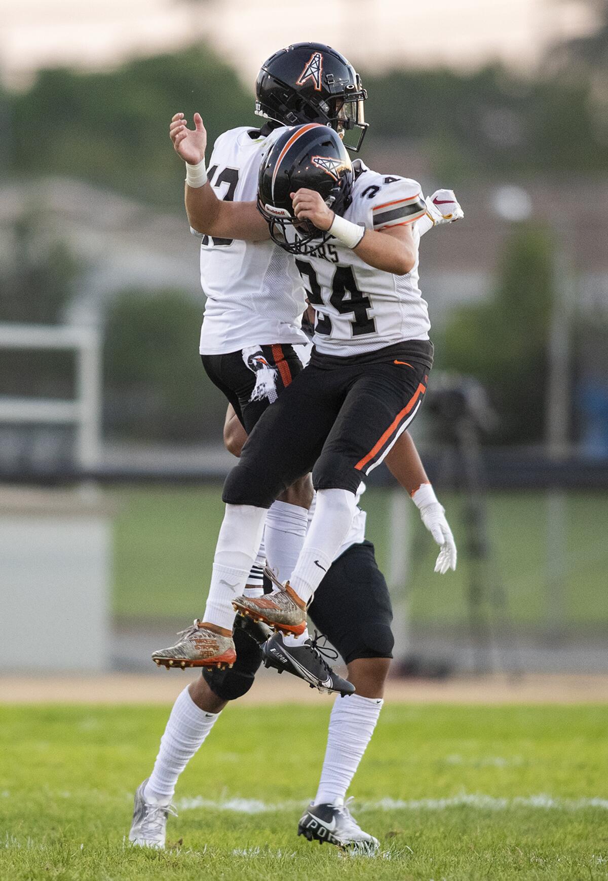 Huntington Beach's Jordan Castro, left, celebrates with Evan Riederich after Castro intercepted a pass.