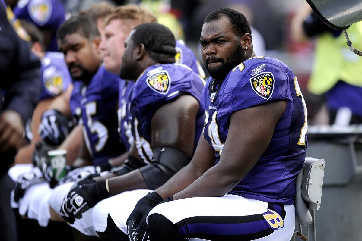 Offensive tackle Michael Oher sits on the bench with his Baltimore Ravens teammates