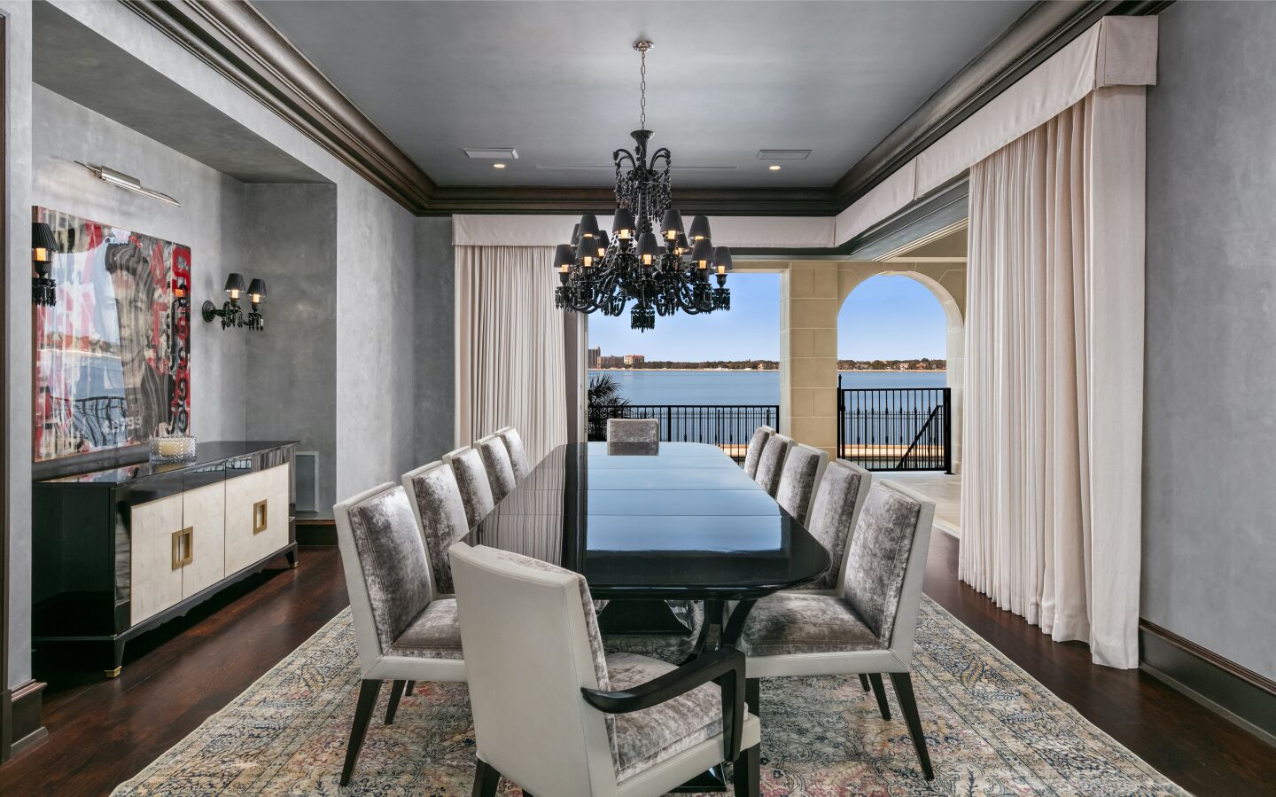 A long table and chandelier occupy a rectangular dining room.