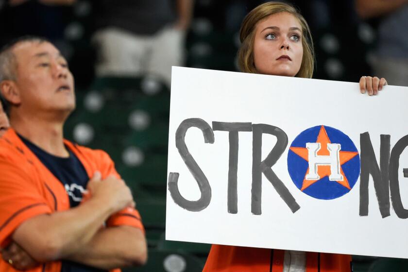 A fan holds a sign during the national anthem before the first game of a baseball doubleheader against the New York Mets, Saturday, Sept. 2, 2017, in Houston. (AP Photo/Eric Christian Smith)