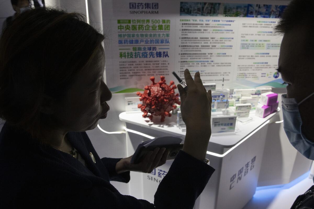 A promoter talks about Sinopharm's COVID-19 vaccine candidate during a trade fair in Beijing in September.