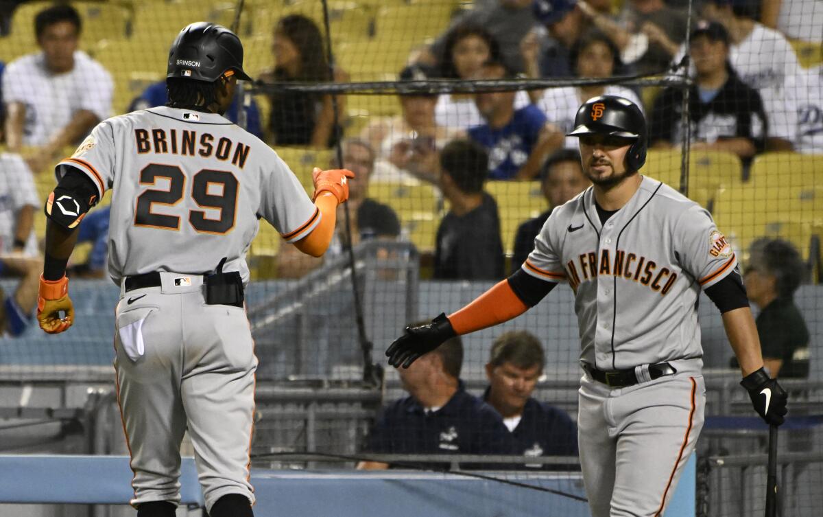 San Francisco Giants' Lewis Brinson points to J.D. Davis (7) after hitting a home run against the Los Angeles Dodgers during the eighth inning of a baseball game Monday, Sept. 5, 2022, in Los Angeles. (AP Photo/John McCoy)