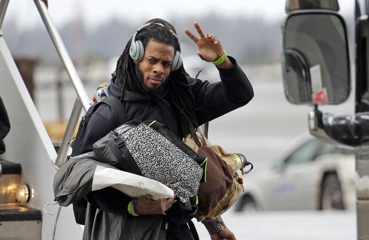 Seattle cornerback Richard Sherman waves to fans who turned out to meet the team upon its return from the Super Bowl on Monday.